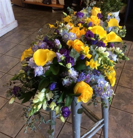 Casket Spray. Yellow Calla and roses, with light blue delphinium, purple lisianthus and Tate-a-Tate daffs