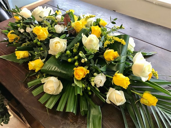 Casket Spray. Small, formal  2 ft, with white and yellow roses and exotic foliages