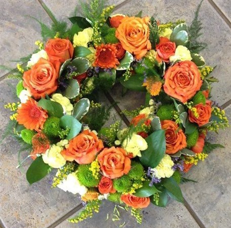 Wreath. Open style with orange roses and yellow carnations, germini