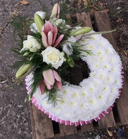Wreath. Massed, pink lily and white rose spray