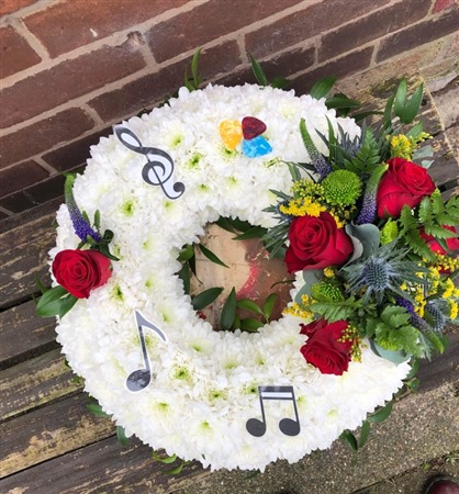 Wreath. Massed with red rose spray and music notes