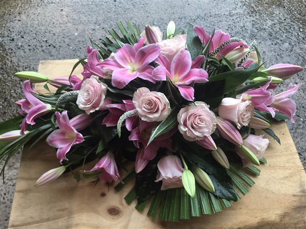 Teardrop. Pink lilies and pink roses, tropical foliages, Formal design.
